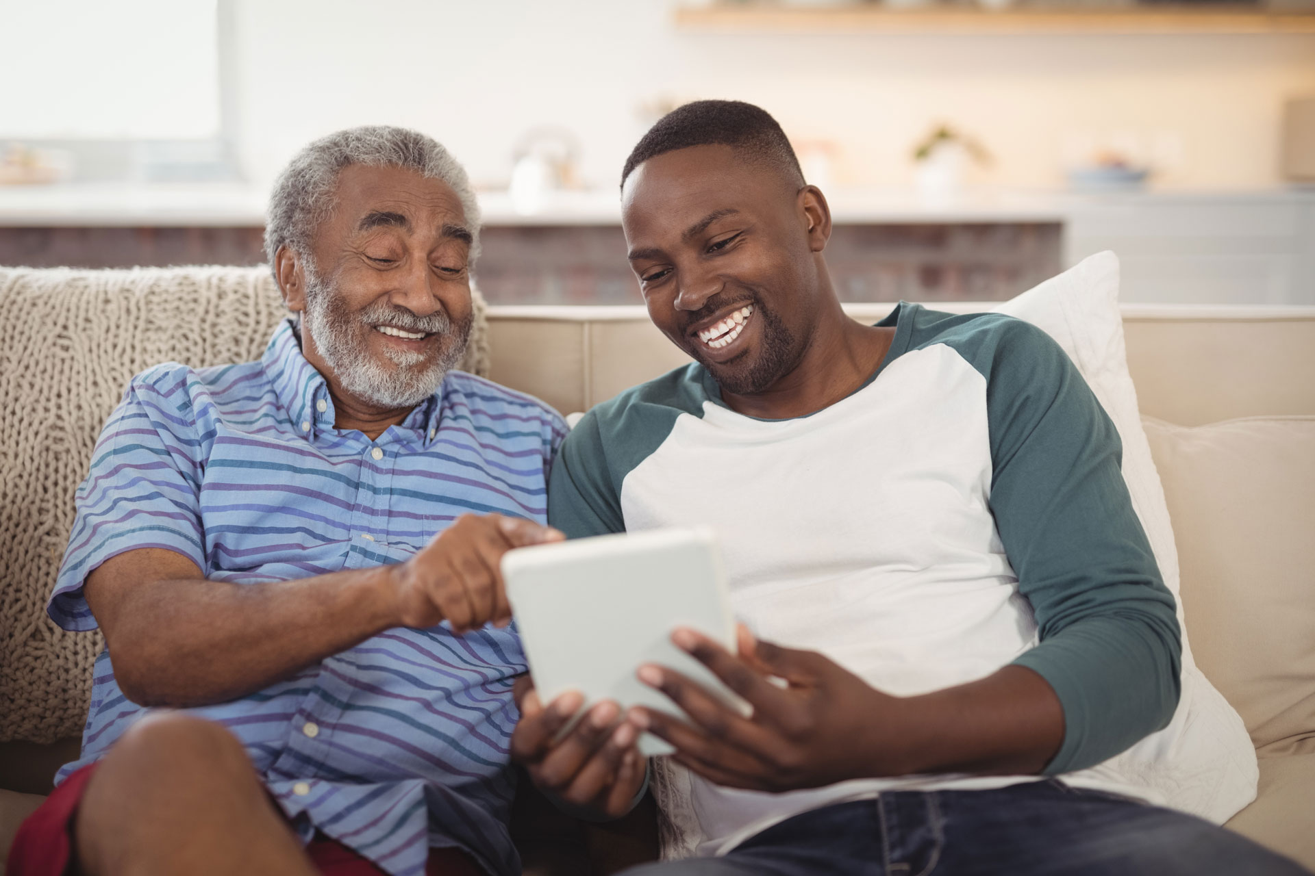 Son and dad looking at a computer tablet together Stock Image