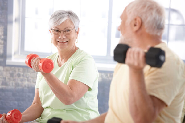 Senior couple exercising, lifting small hand weights